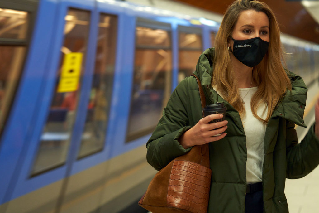 Frau mit Maske vor U Bahn